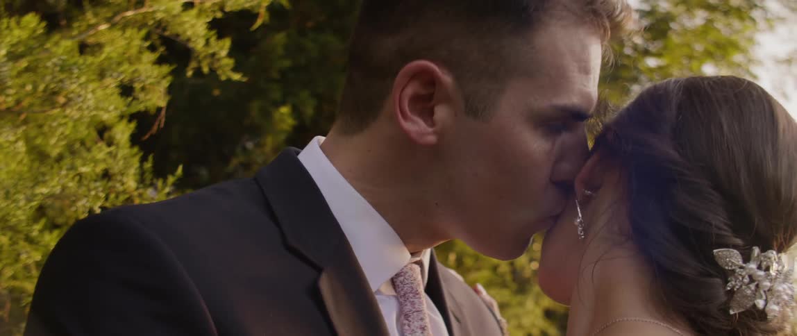 A groom kisses his bride's cheek