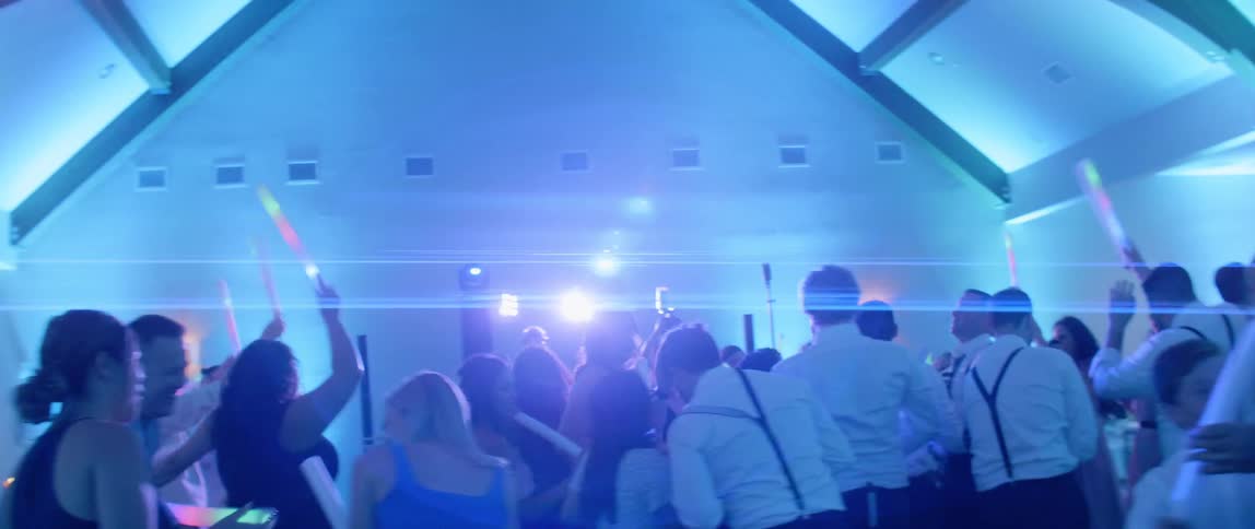 People at a party dance and wave light sticks