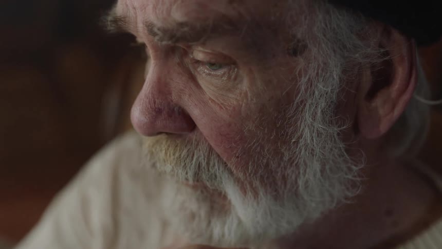 Older man with beard in beanie gazing