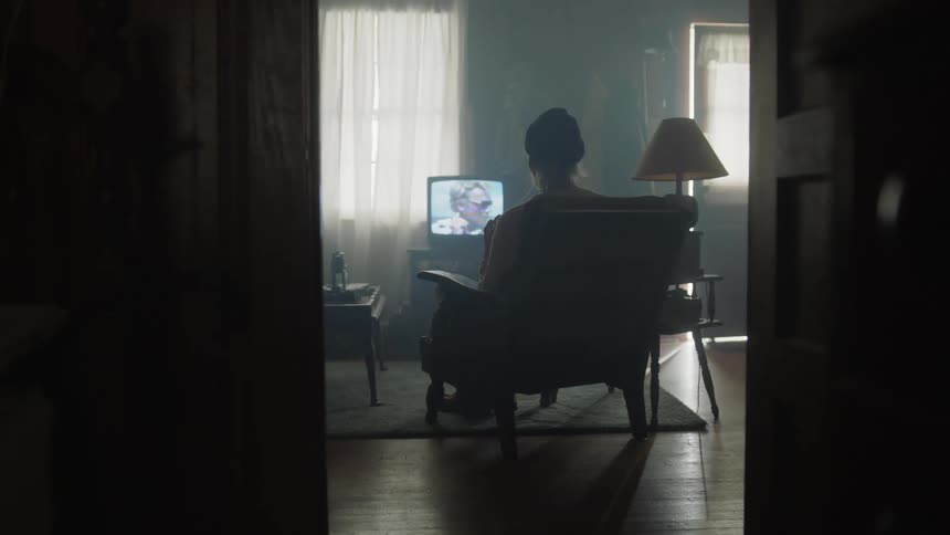 Woman sitting in chair watching tv