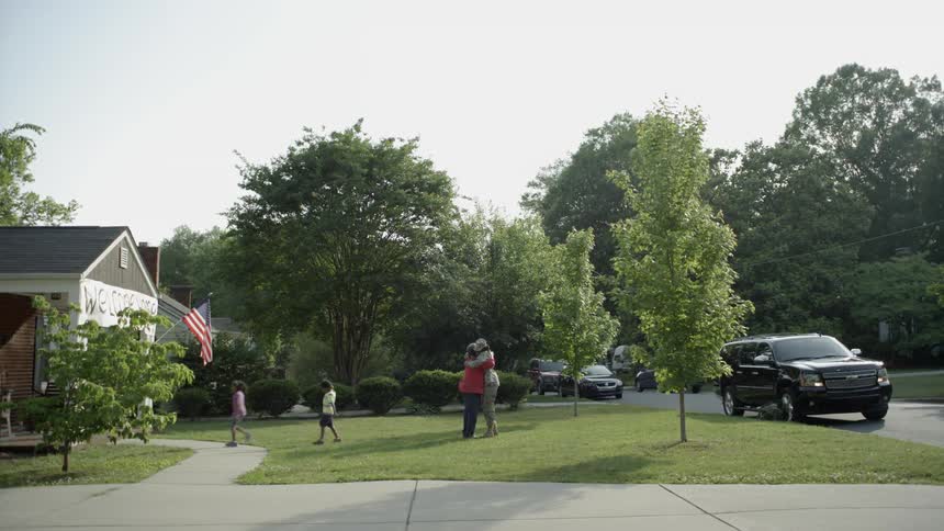 People greet each other on the front lawn