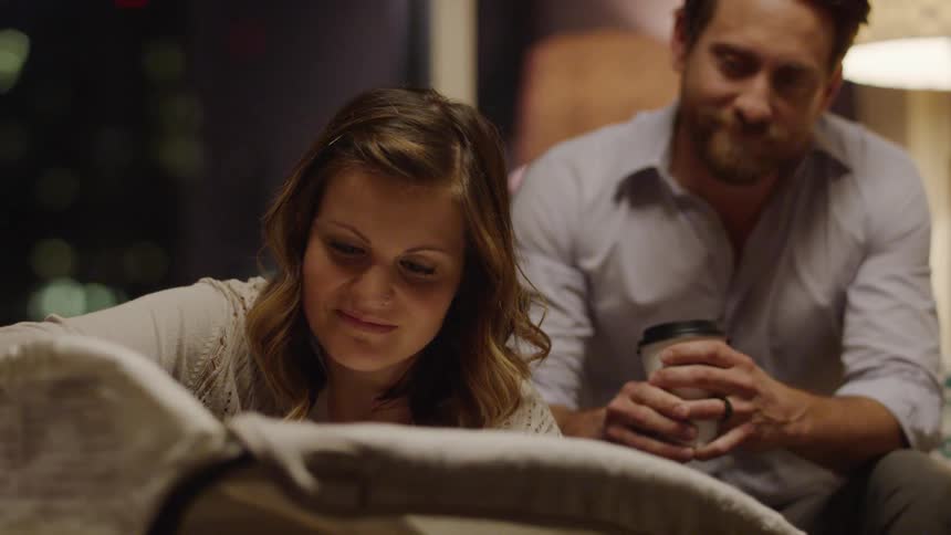 Man and woman sit gazing and smiling