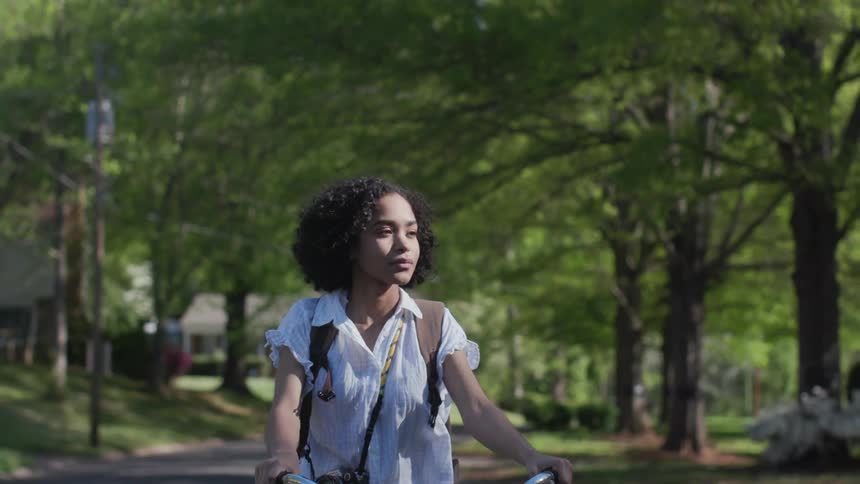 A woman rides her bicycle on the neighborhood street