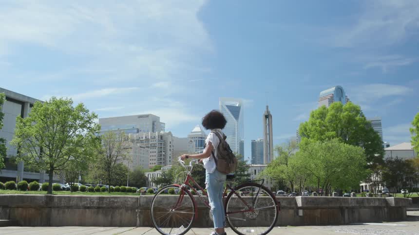 Girl on bike stops and looks at skyline