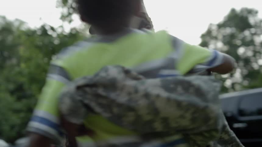 Children run up and hug a soldier