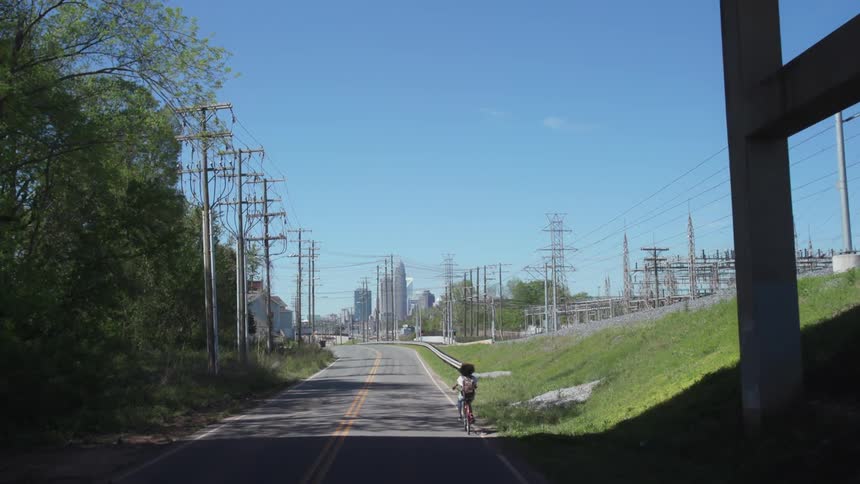 A woman rides her bike down the street