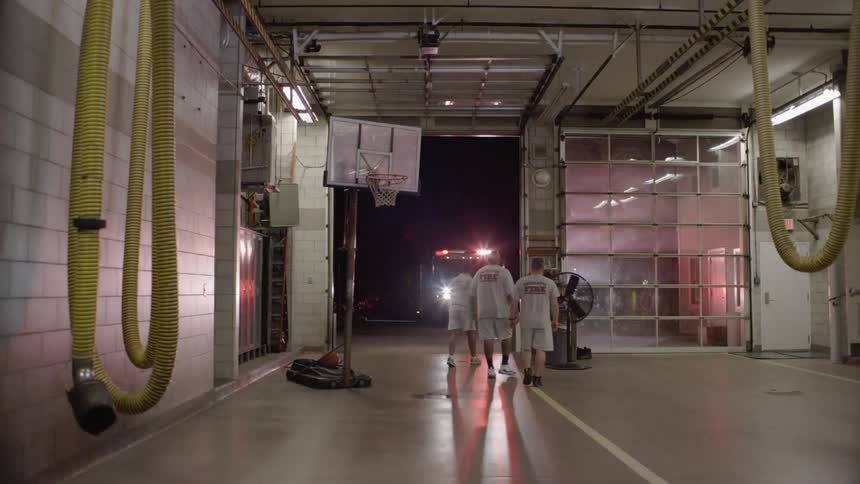 Men walk out of the fire station at night