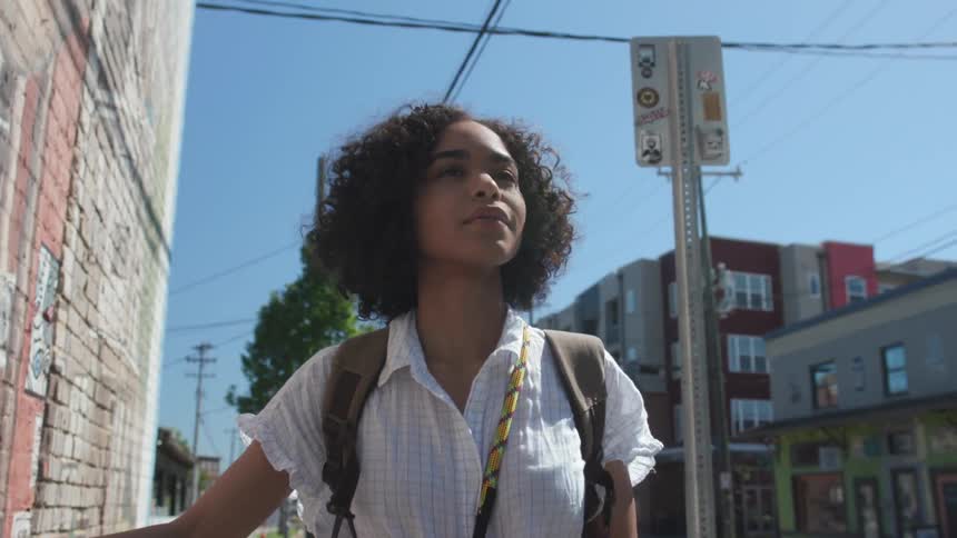 A woman walks on the city sidewalk