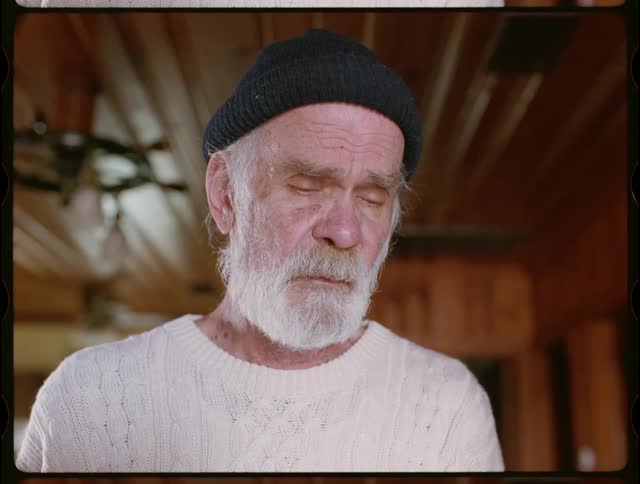 Man with beard and beanie looks down