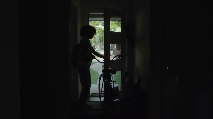 A woman exits the front door with a bicycle