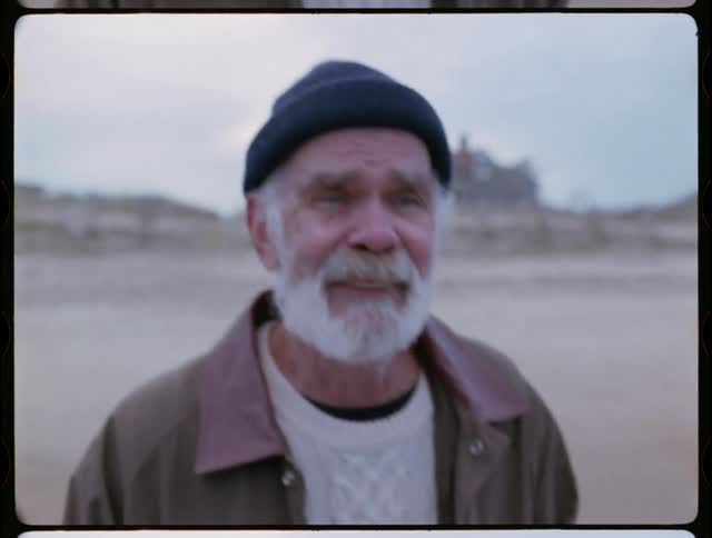 Older man is smiling and crying as he walks towards the ocean