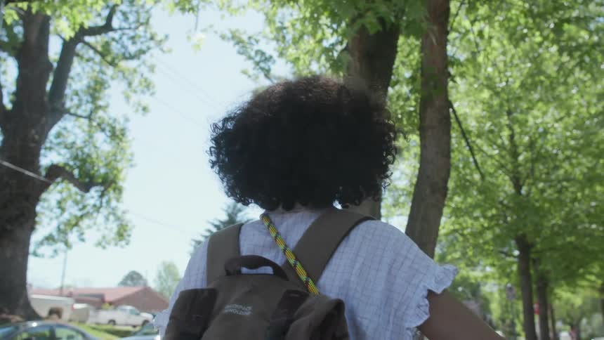 A woman walks on the city sidewalk