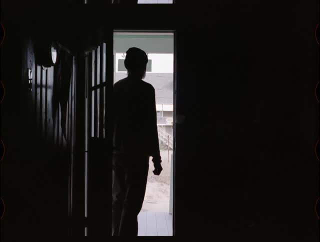 A man looks out an open front door