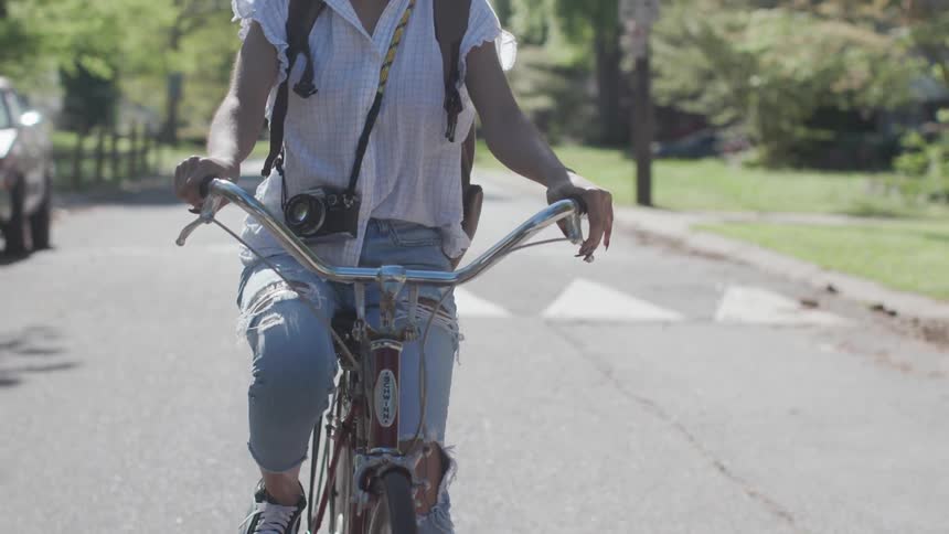 Woman riding a bicycle through a neighborhood during the afternoon