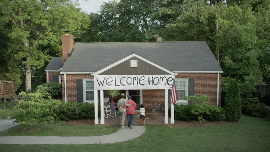 Family welcoming a soldier home and walking into house