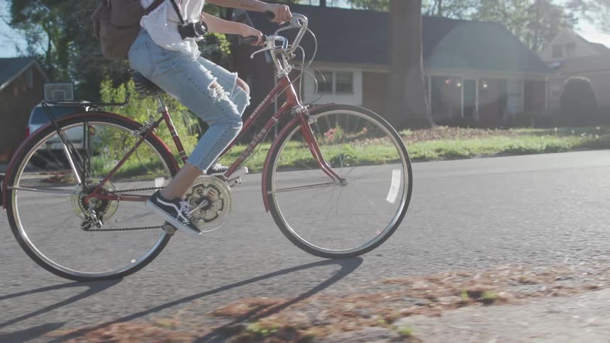 Girl rides bike along suburban street
