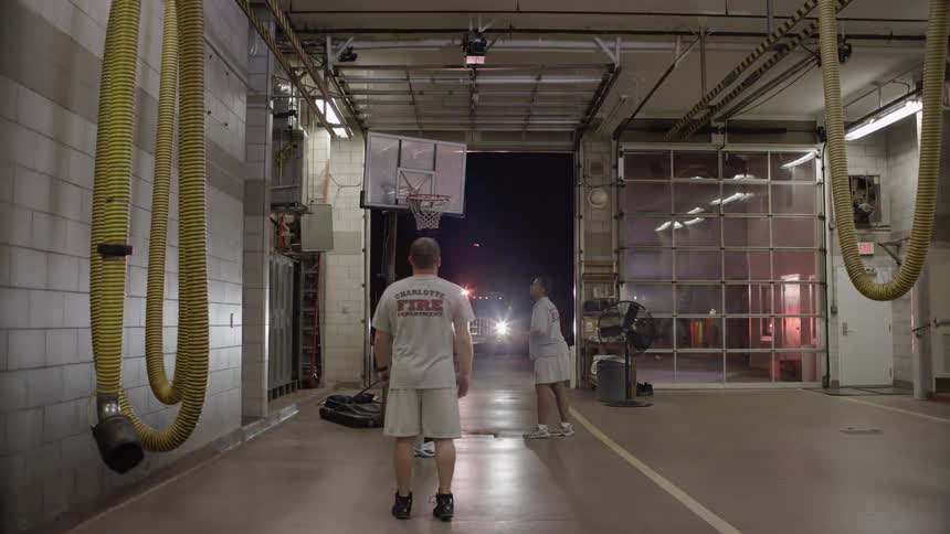 Firefighters shoot a basketball then walk out of the firehouse
