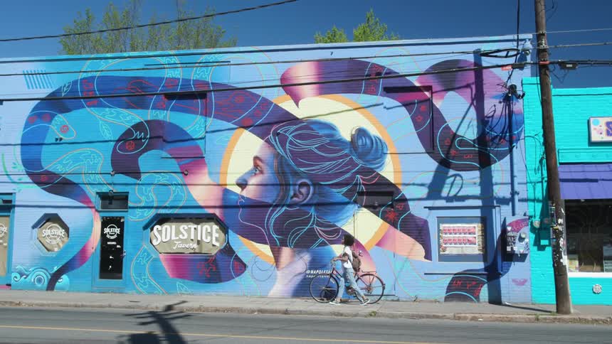 Woman walking a bicycle through the city in the afternoon