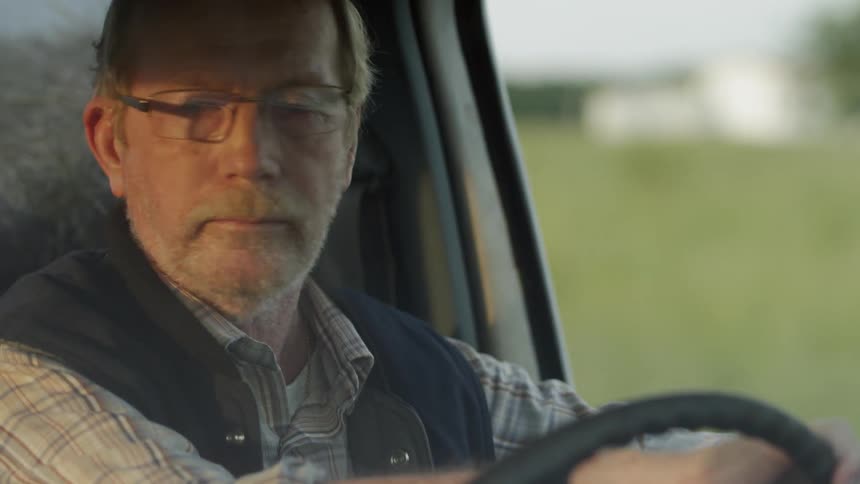 Man driving through a neighborhood in a truck