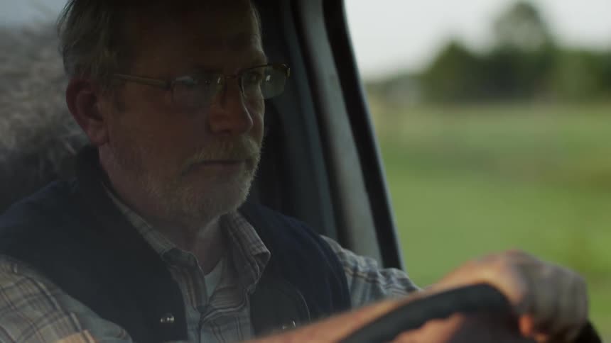 Man driving through a neighborhood in a truck
