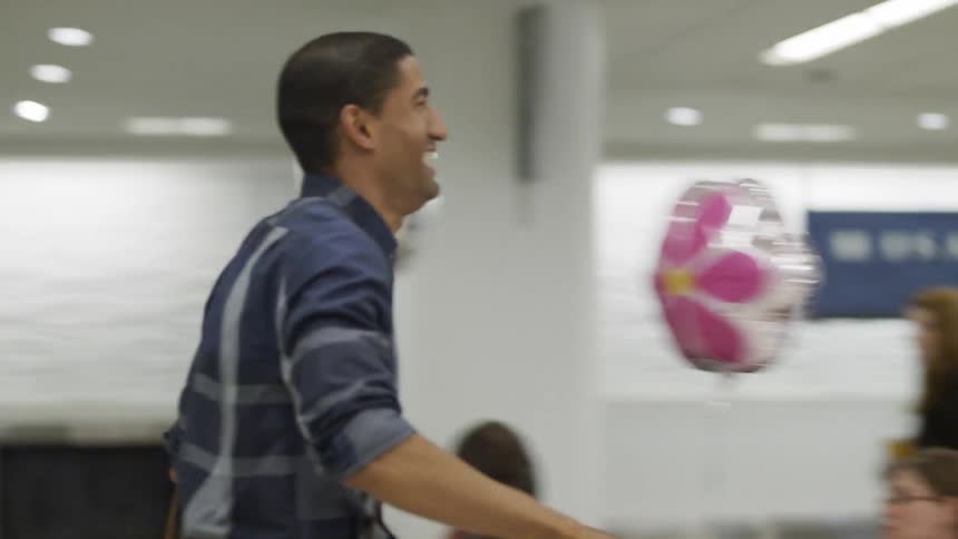 Man and woman walk through an airport and hug each other