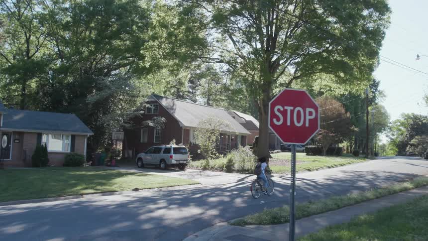 A woman rides a bicycle on a neighborhood street