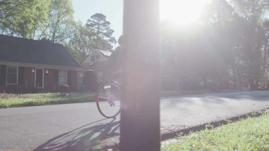 A woman rides a bicycle on a neighborhood street