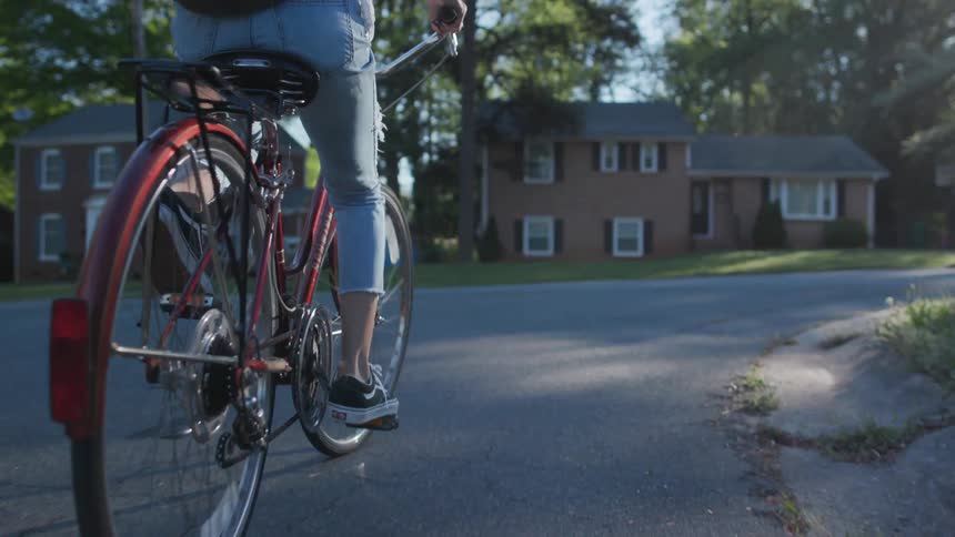 A bicyclist rides on a neighborhood street