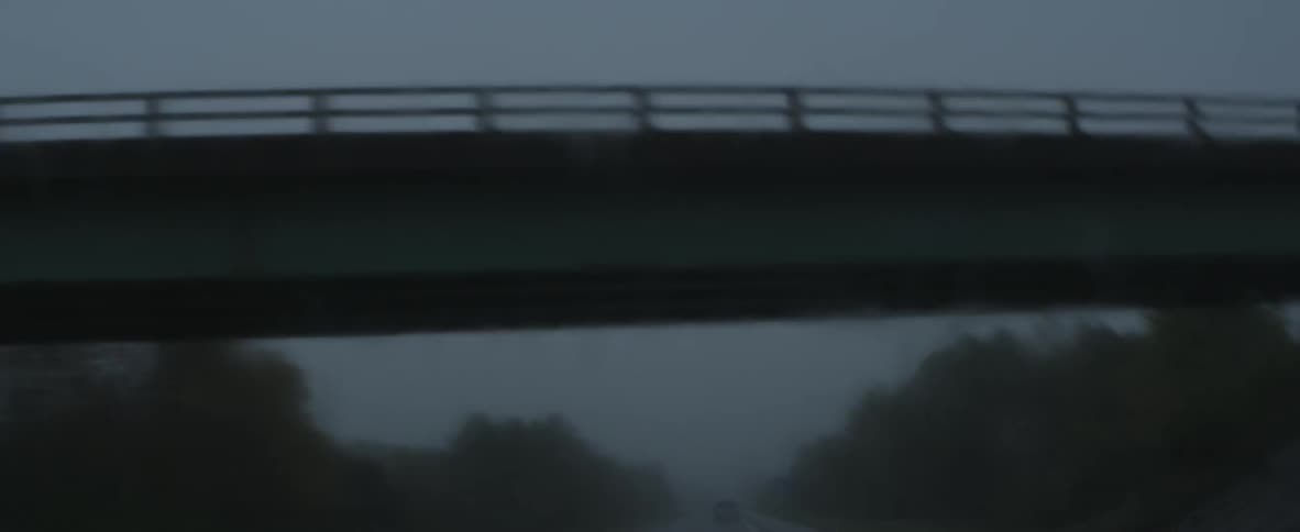 A vehicle travels under a bridge