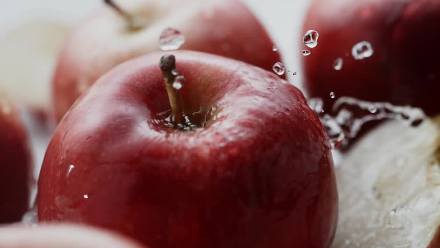 Water is splashing over apples and apple slices
