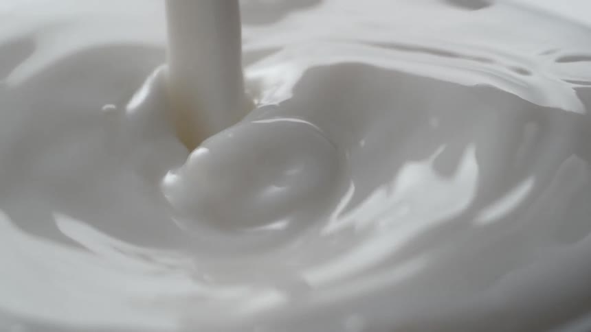 Milk splashes into a glass