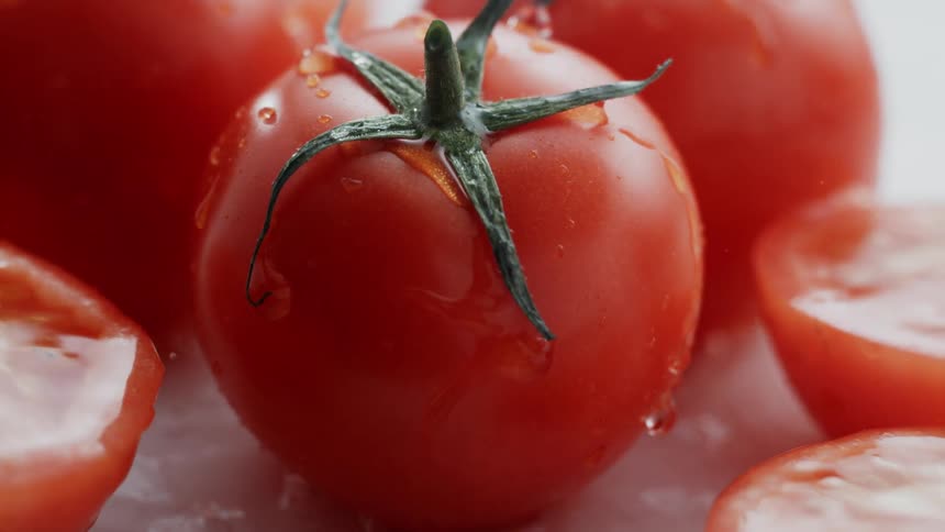 Water splashes onto several tomatoes