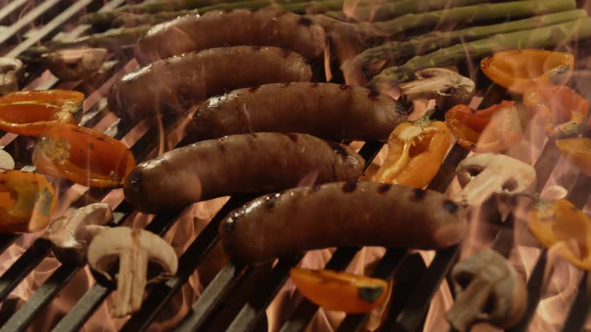 Food cooking on a grill grate with flames below it