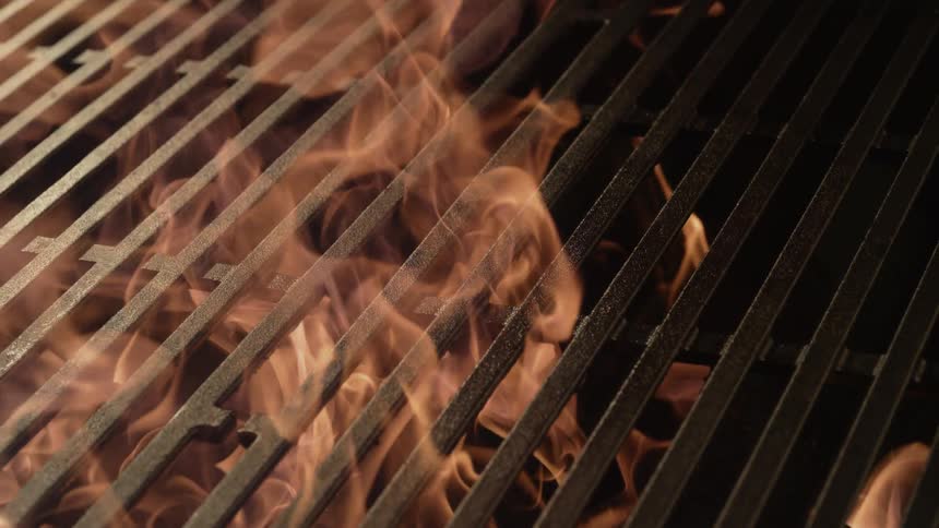 Fire leaps above the grill grates