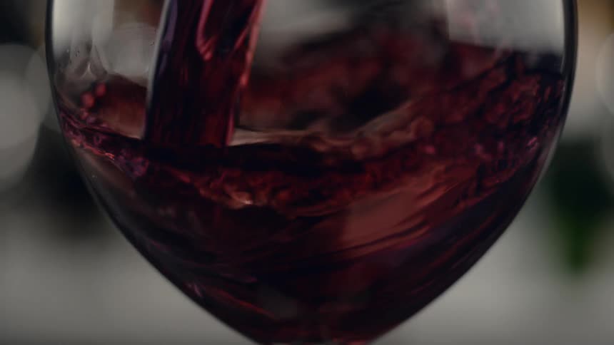 Red wine pours into a glass