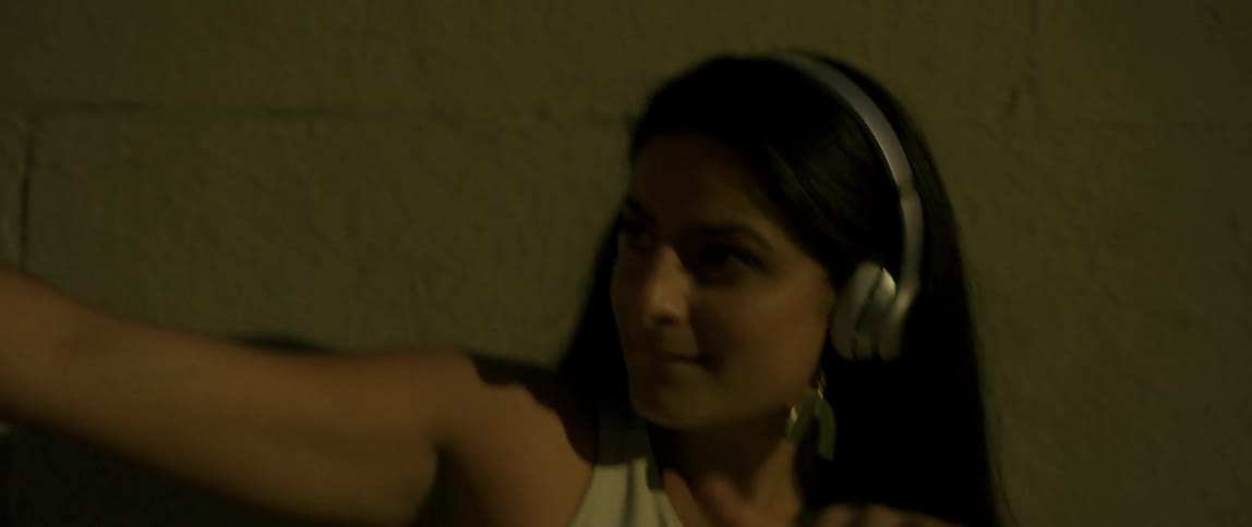 Woman listening to music and dancing in the street at night