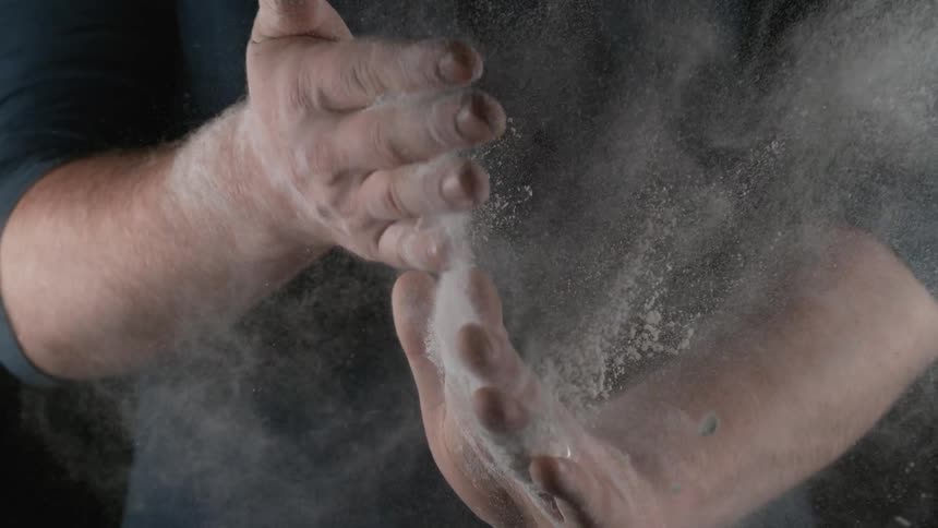 A man smacks powder off his hands
