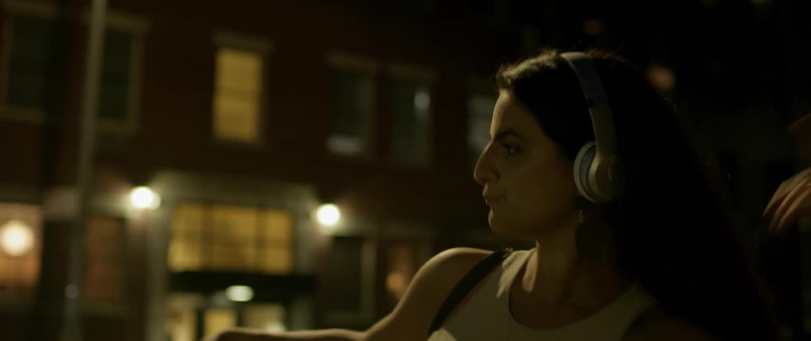 A woman dances playfully at night