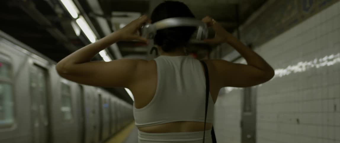A woman twirls as a train passes