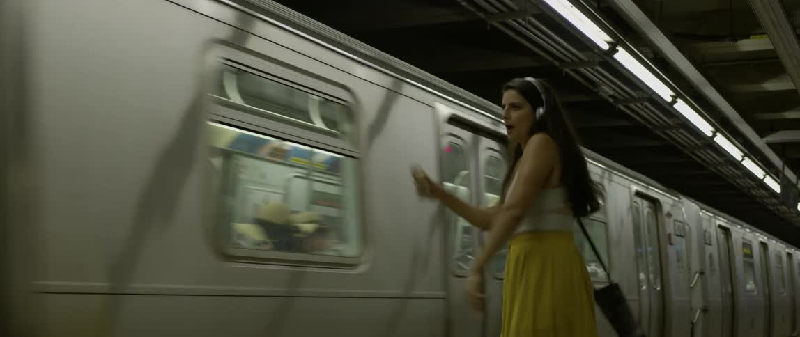 A woman dances as a subway train passes