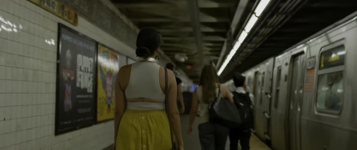 A woman in headphones walks in the subway station
