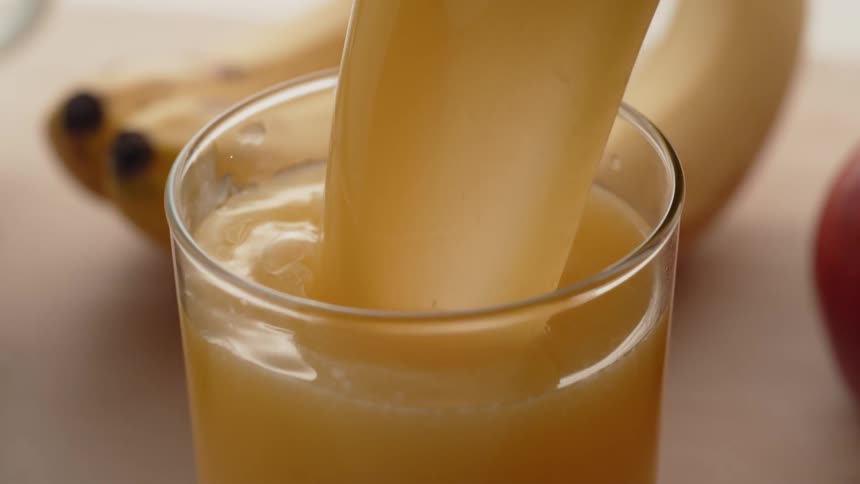 Orange juice is poured into a glass