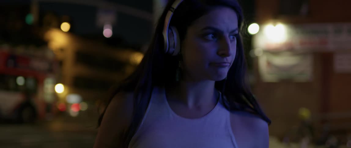 A woman is dancing in the street at night