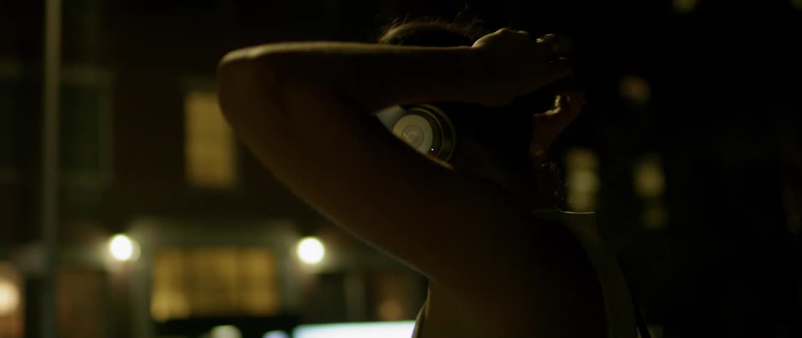 A woman dances outside at night