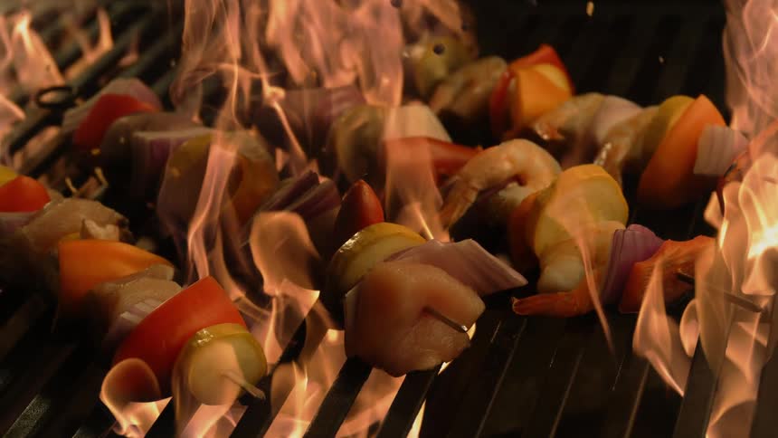 Chicken and vegetable kebabs are cooked on the grill