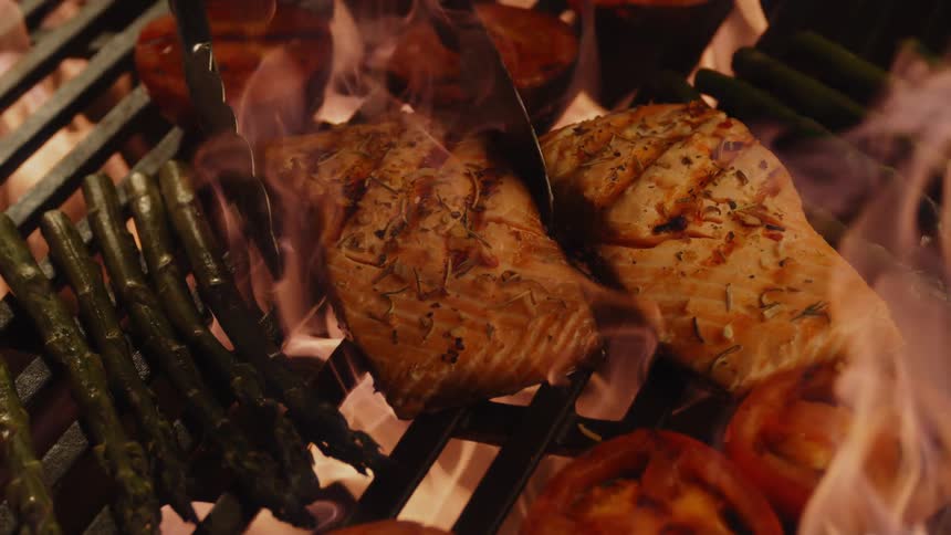 Salmon and vegetables are cooked on the grill