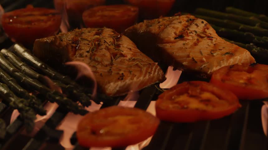 Meat and vegetables being cooked over open flame