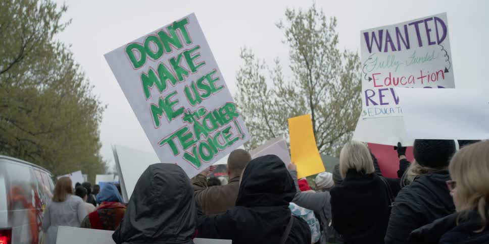Protesters march together on an overcast day