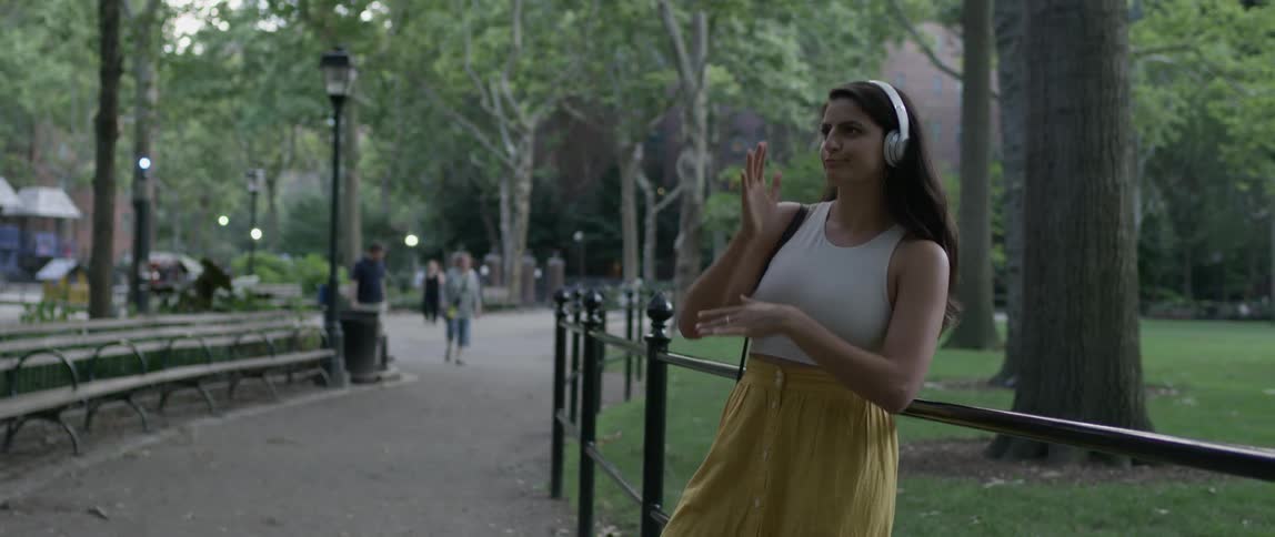 Woman listening to music and dancing in the park