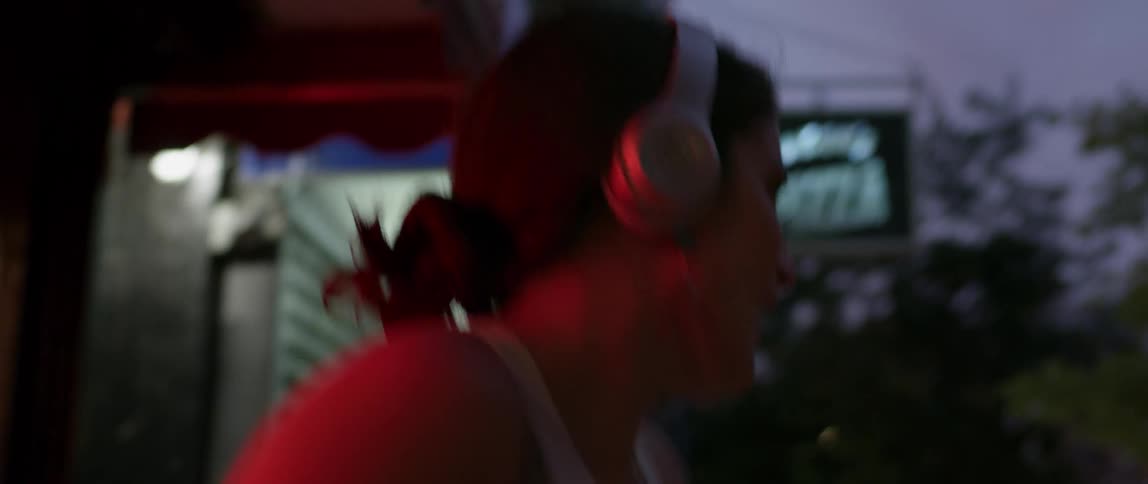 Woman wearing headphones dances in the street